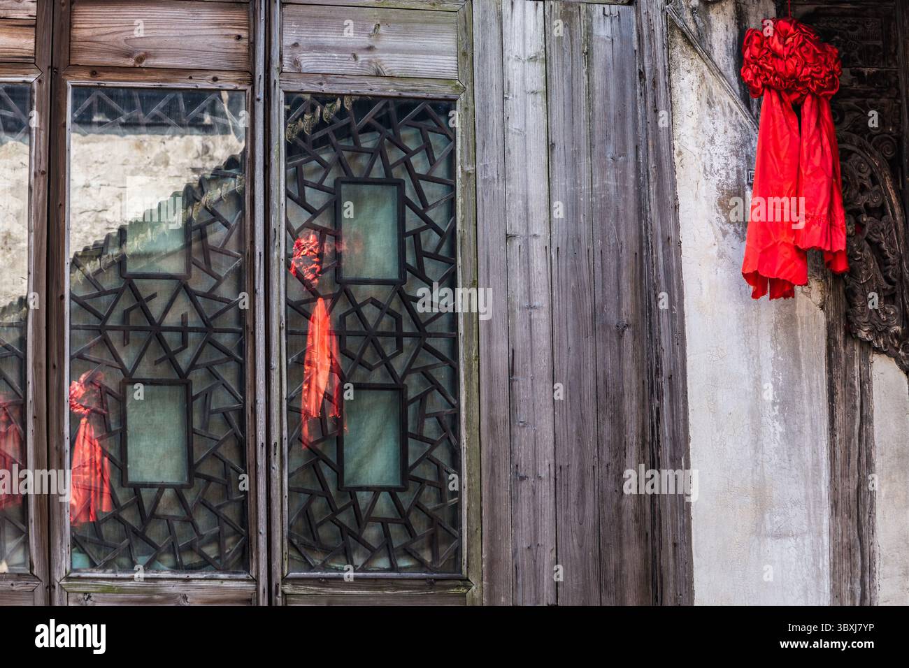 18. Mai 2013, Wuzhen, Provinz Zhejiang, China: Rote Bänder spiegeln sich im Fenster einer alten Wohnung in der Stadt Wuzhen, China. (Kreditbild: © Jon G. Fuller/VW Pics via ZUMA Press Wire) Stockfoto