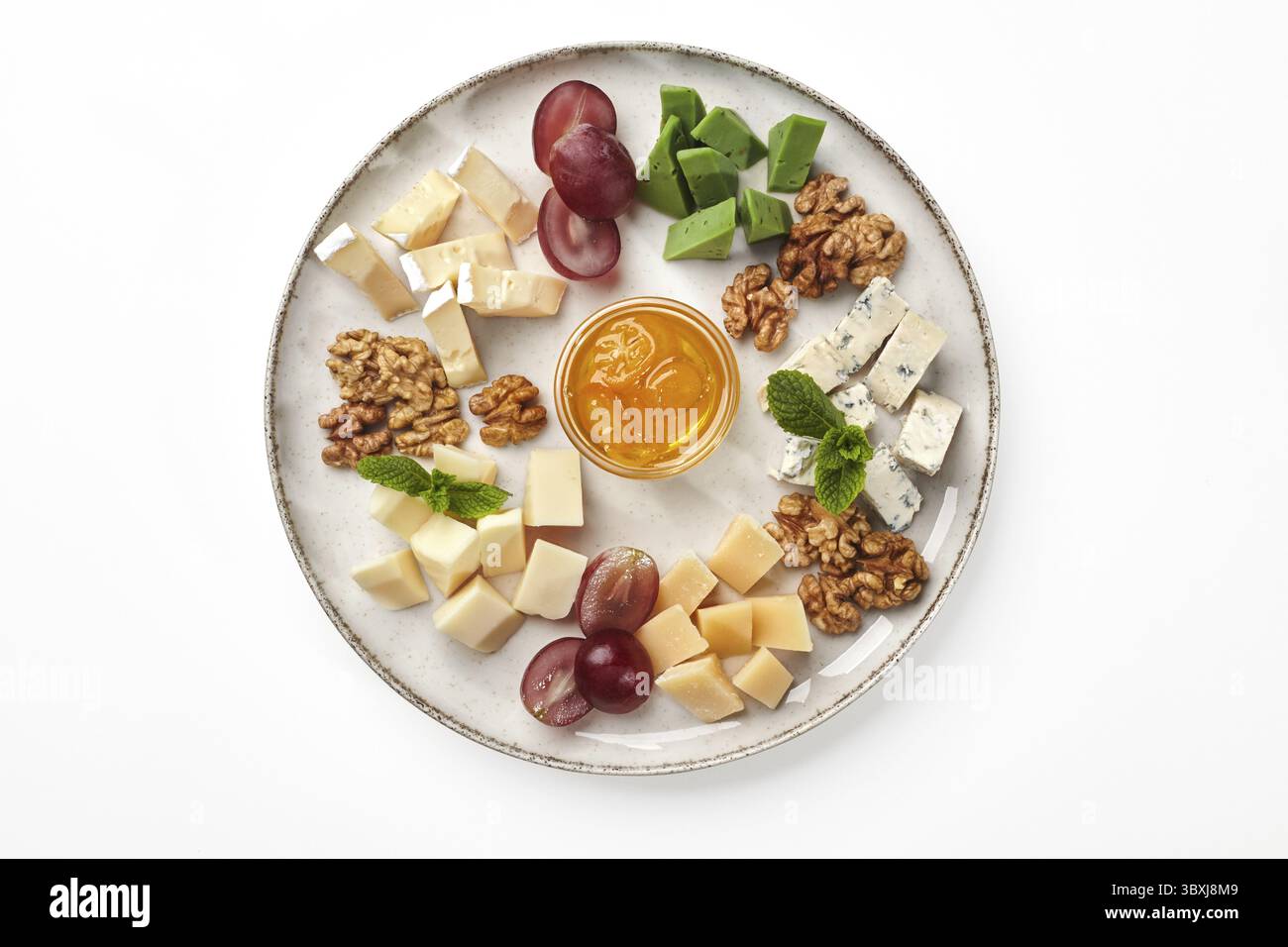Köstliche Platte mit Scheiben von weichem und festem Käse, Dor-blauem und grünem Pesto. Fünf Käsesorten, die traditionell mit Honig und Gra serviert werden Stockfoto