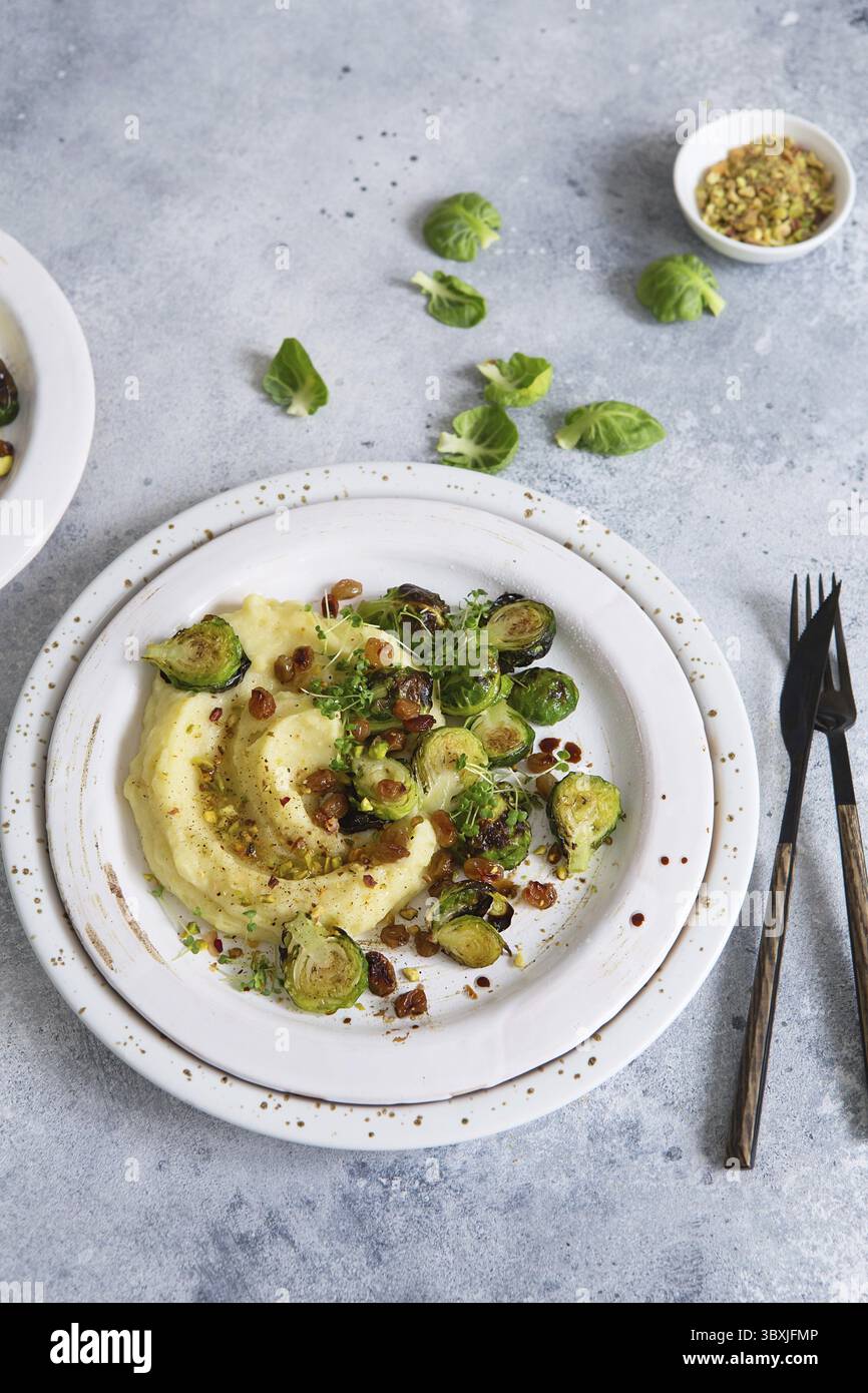 Rosenkohl mit Pistazien, Rosinen und Skordalia (Kartoffelpüree). Gesunde Zubereitung von Mahlzeiten. Gerichte auf pflanzlicher Basis. Grünes Leben. Veganes Rezept. F Stockfoto