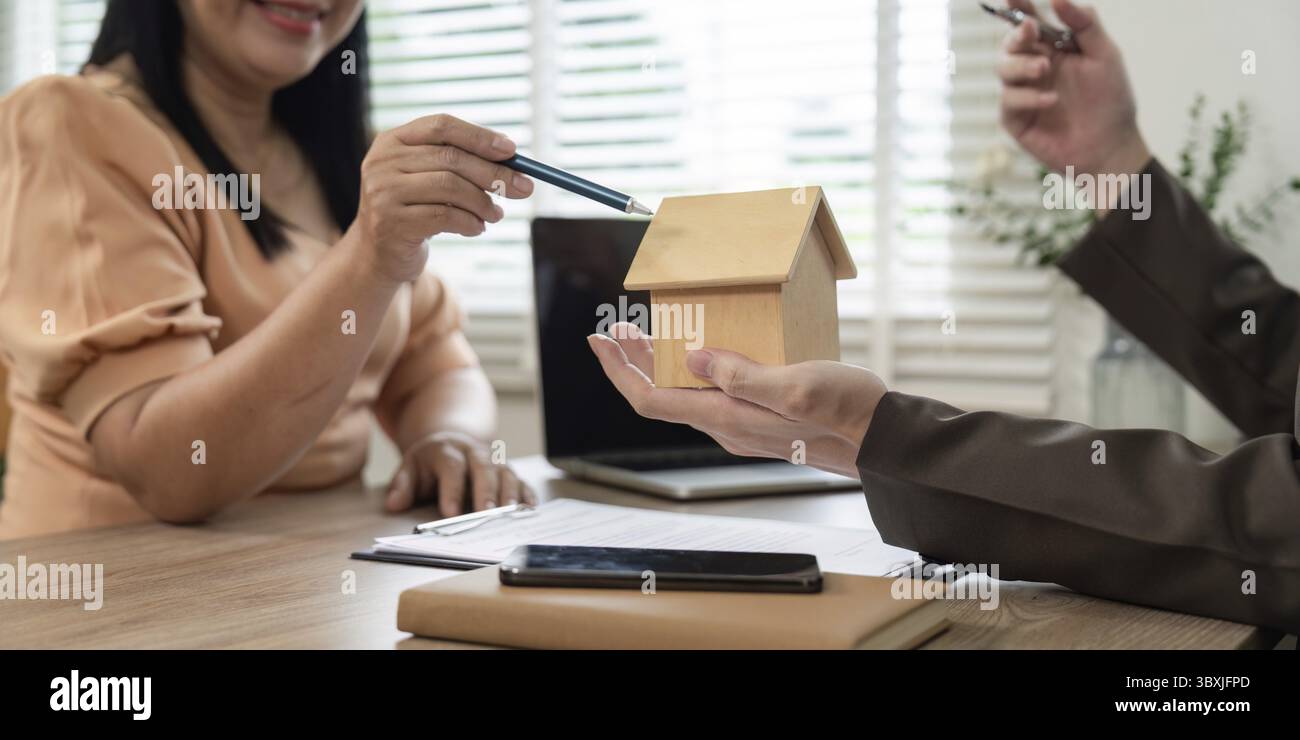 Ein Immobilienmakler berät einen Kunden über die Verpflichtungen im Zusammenhang mit dem Immobilienkauf und konzentriert sich dabei auf die Sicherung zukünftiger Stabilität durch fundierte Entscheidungen Stockfoto
