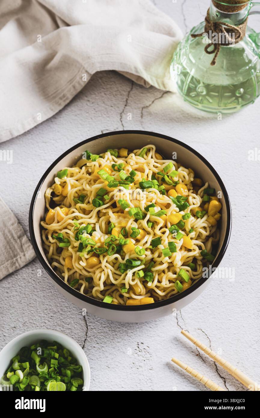Essen, Eine Schüssel mit Instant-Nudeln und Gemüse auf dem Tisch, vertikal Stockfoto