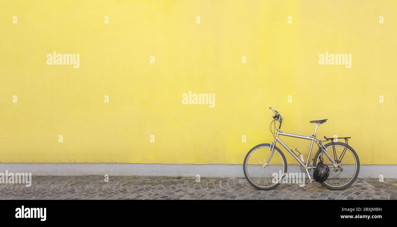 Schwarzes Fahrrad parkt neben einer Betonmauer. Banner, Kopierbereich. Stockfoto
