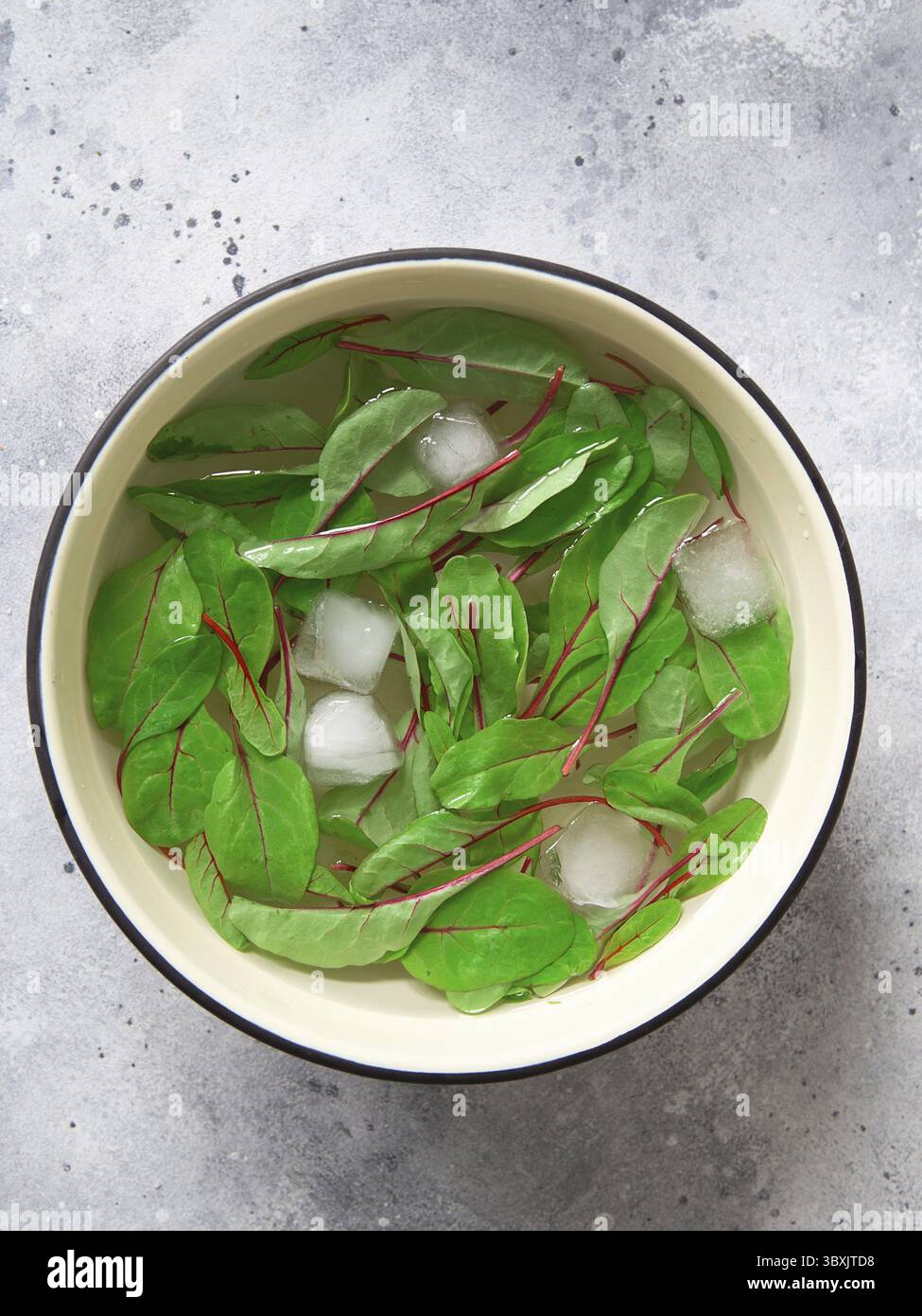 Roter Mangold in einem kalten Eiswasser. Gesunde Mahlzeit Rezept Zubereitung. Gerichte auf pflanzlicher Basis. Grünes Leben. Vegetarische Rezepte. Styling von Lebensmitteln. Bio-Lebensmittel. Vege Stockfoto