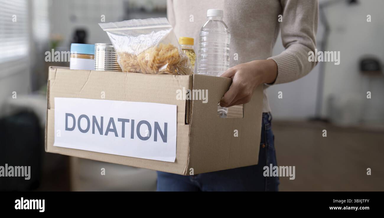 Eine Freiwillige hält eine Lebensmittelspendebox zu Hause Stockfoto
