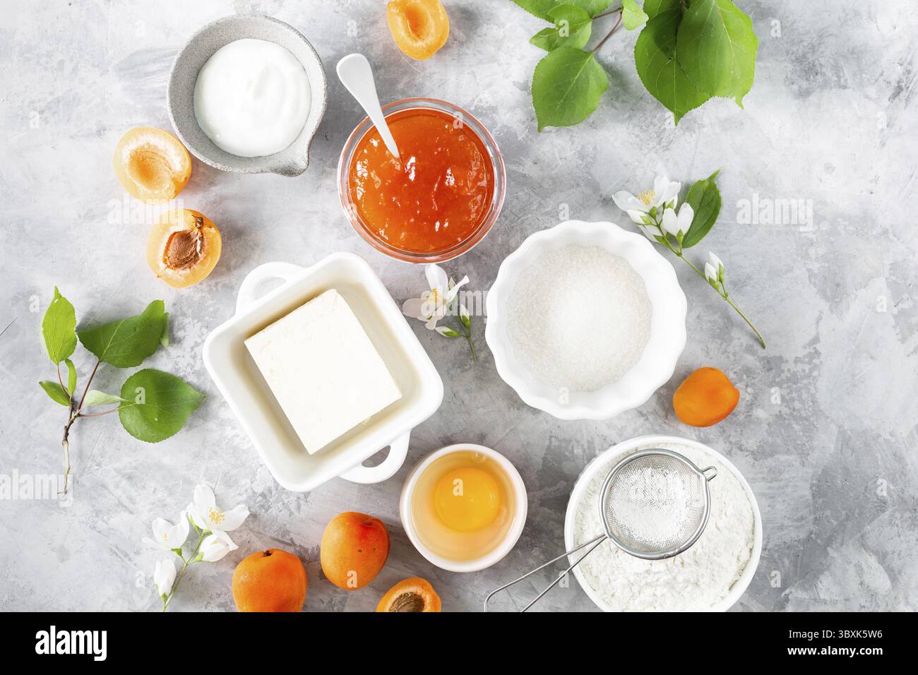 Lebensmittel, Produkte für die Zubereitung französischer Kekse oder Aprikosenkuchen. Zutaten zum Backen im Sommer auf einem hellen Tisch Stockfoto
