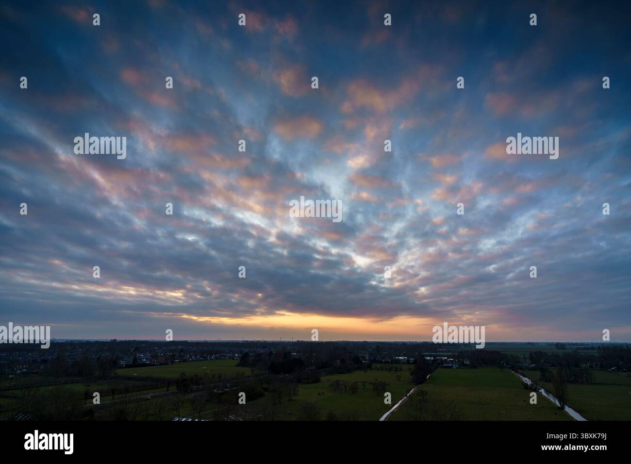 Atemberaubender Balkonblick mit Blick auf die Skyline von Purmerend während eines stürmischen Sonnenuntergangs in der Nähe von Amsterdam, Niederlande Stockfoto