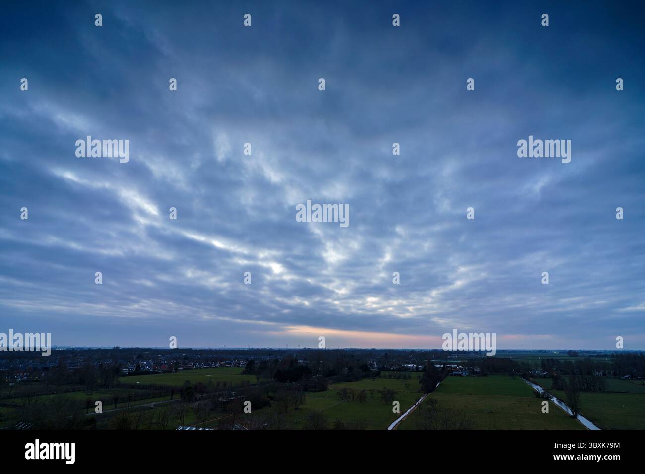 Atemberaubender Balkonblick mit Blick auf die Skyline von Purmerend während eines stürmischen Sonnenuntergangs in der Nähe von Amsterdam, Niederlande Stockfoto