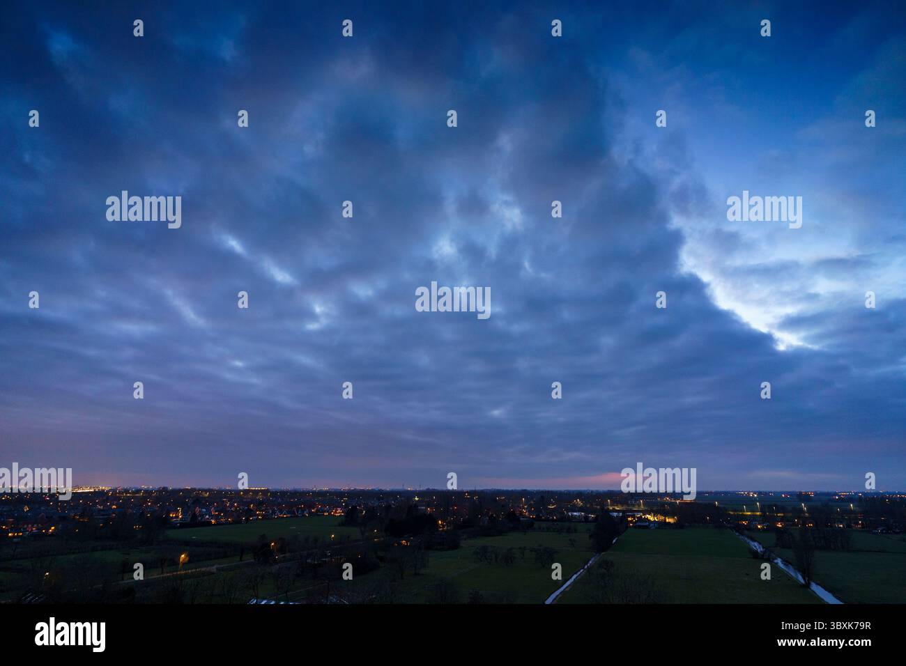 Atemberaubender Balkonblick mit Blick auf die Skyline von Purmerend während eines stürmischen Sonnenuntergangs in der Nähe von Amsterdam, Niederlande Stockfoto