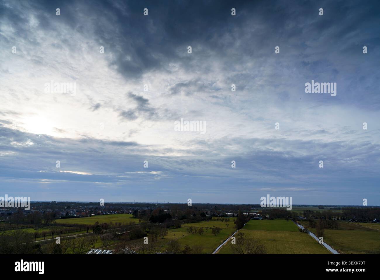 Atemberaubender Balkonblick mit Blick auf die Skyline von Purmerend während eines stürmischen Sonnenuntergangs in der Nähe von Amsterdam, Niederlande Stockfoto