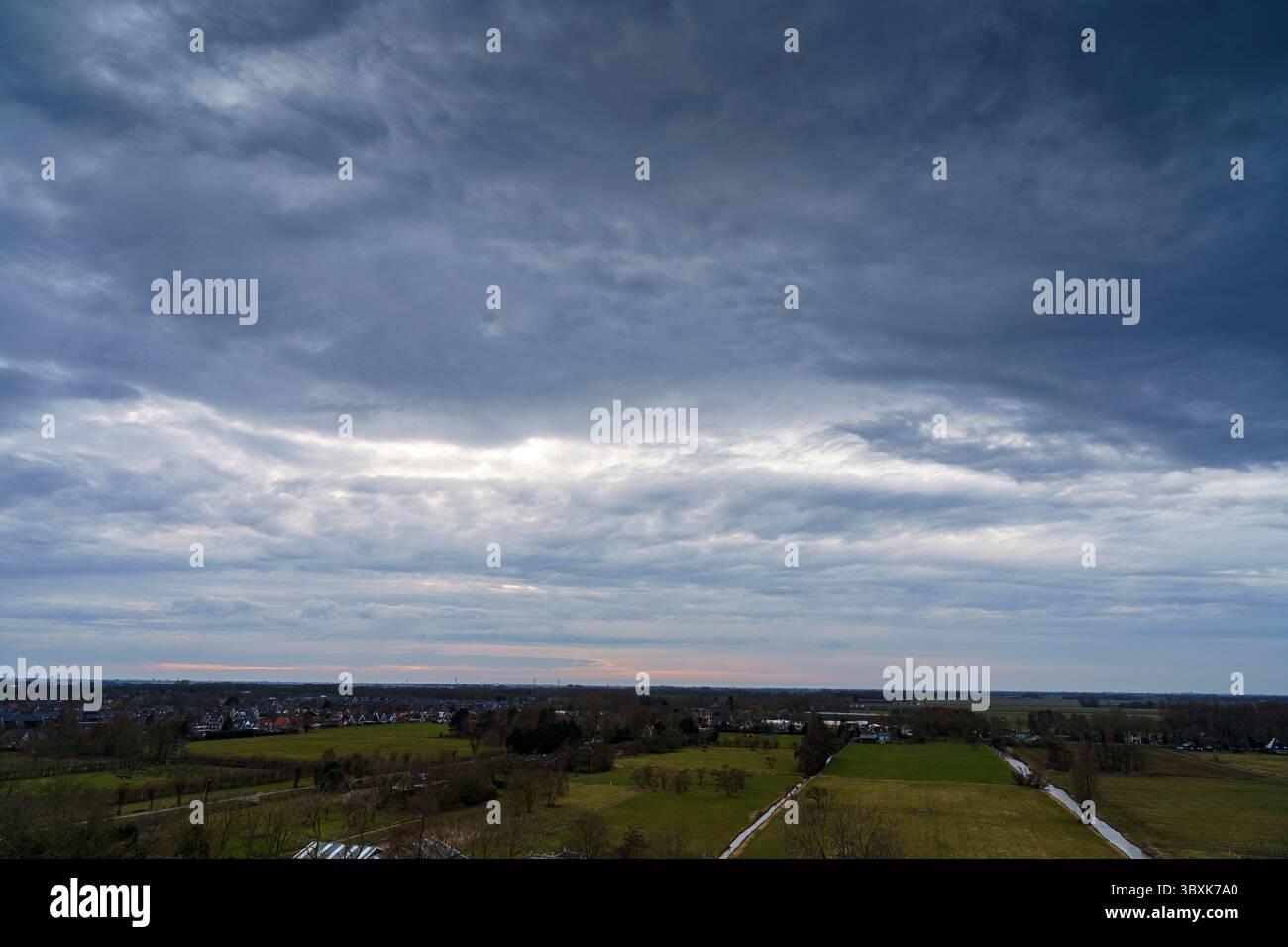 Atemberaubender Balkonblick mit Blick auf die Skyline von Purmerend während eines stürmischen Sonnenuntergangs in der Nähe von Amsterdam, Niederlande Stockfoto