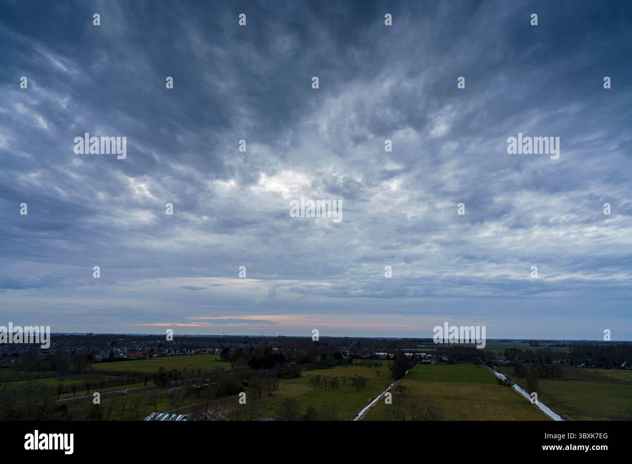 Atemberaubender Balkonblick mit Blick auf die Skyline von Purmerend während eines stürmischen Sonnenuntergangs in der Nähe von Amsterdam, Niederlande Stockfoto