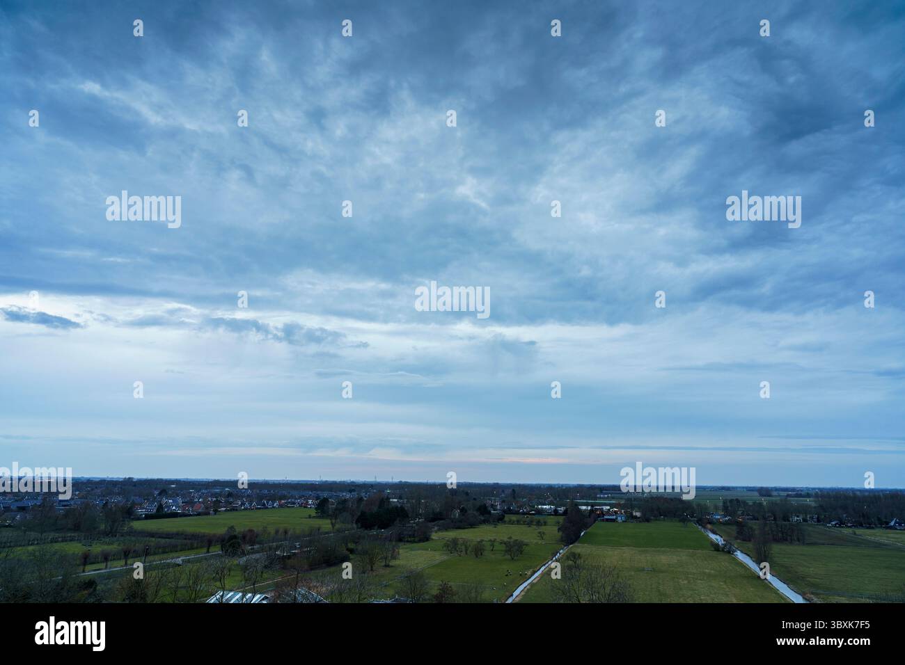 Atemberaubender Balkonblick mit Blick auf die Skyline von Purmerend während eines stürmischen Sonnenuntergangs in der Nähe von Amsterdam, Niederlande Stockfoto
