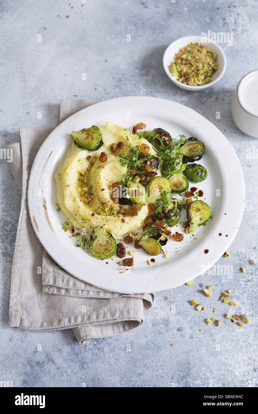 Rosenkohl mit Pistazien, Rosinen und Skordalia (Kartoffelpüree). Gesunde Zubereitung von Mahlzeiten. Gerichte auf pflanzlicher Basis. Grünes Leben. Veganes Rezept. F Stockfoto