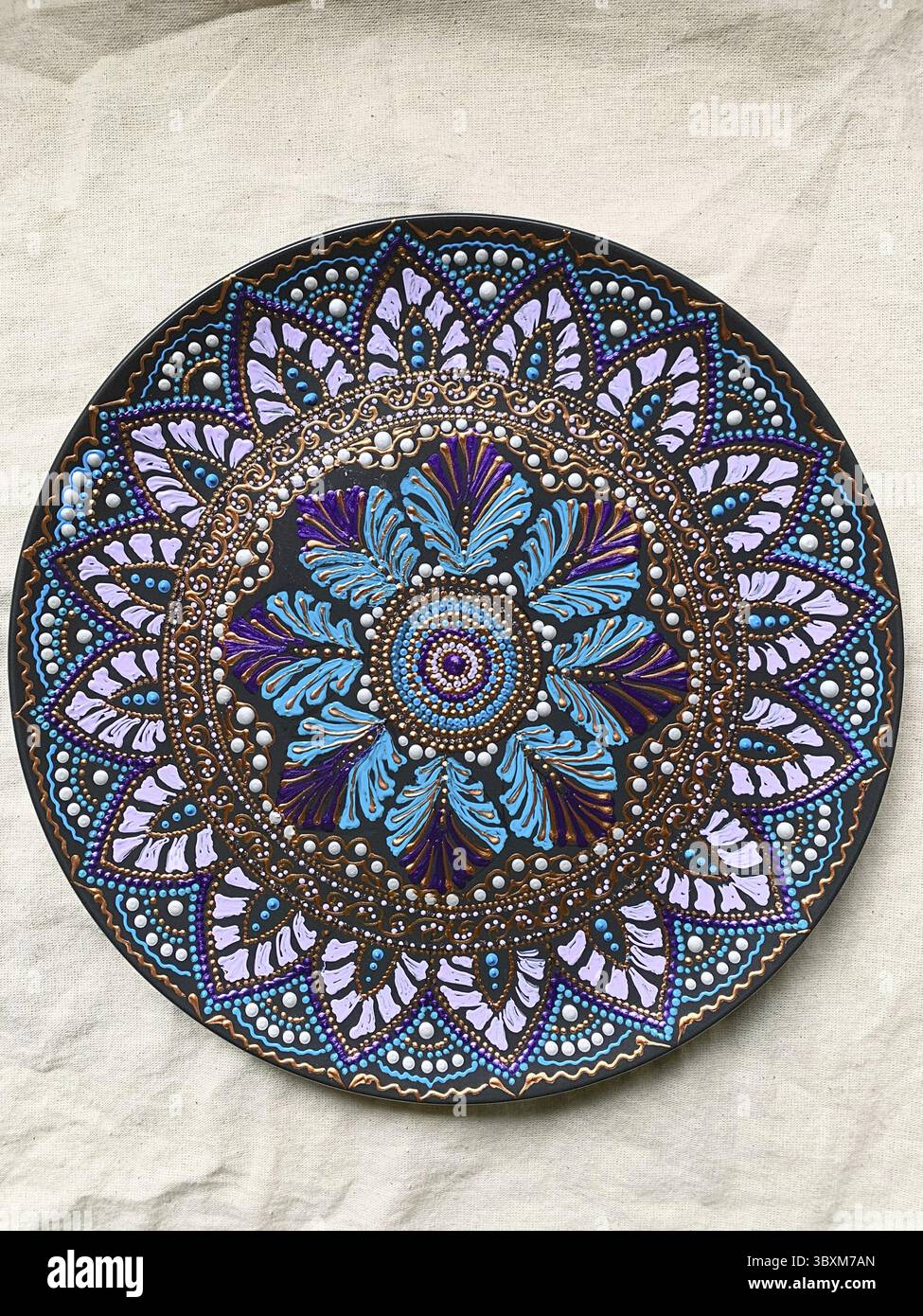 Dekorative Keramikplatte in verschiedenen Farben. Gemalte Platte auf weißem Hintergrund, Nahaufnahme, Draufsicht. Dekorative Porzellanplatte mit Acryl bemalt Stockfoto