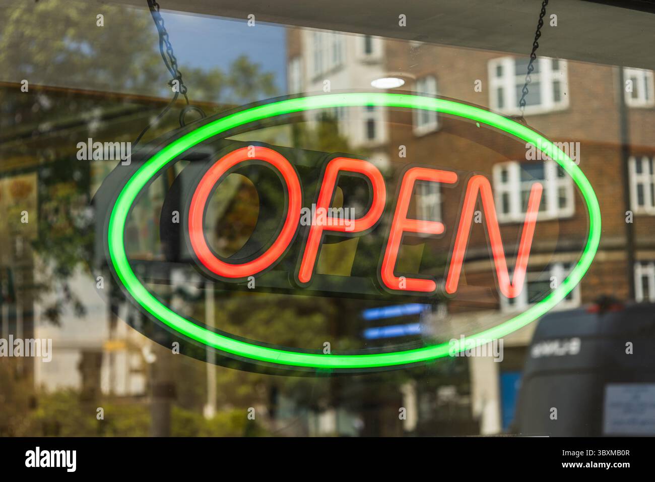 Helles Neonschild im Schaufenster mit grünem, ovalem Rand Stockfoto