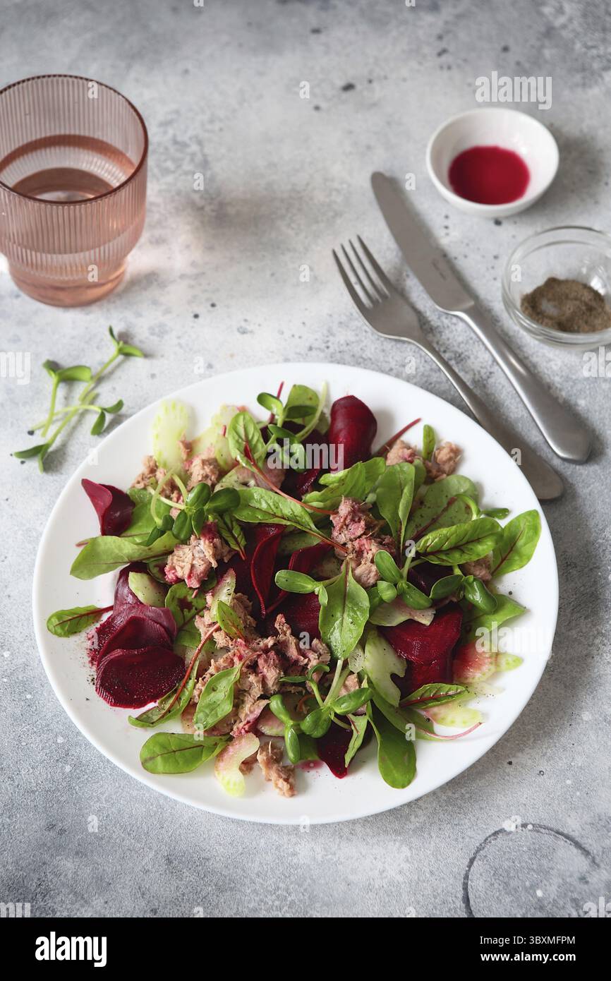 Gesunder, frischer Salat. Rote Bete, rote Mangold und Thunfischkonserven. Gesunde Mahlzeit Rezept Zubereitung. Gerichte auf pflanzlicher Basis. Grünes Leben. Vegetarische Rezepte. Stockfoto