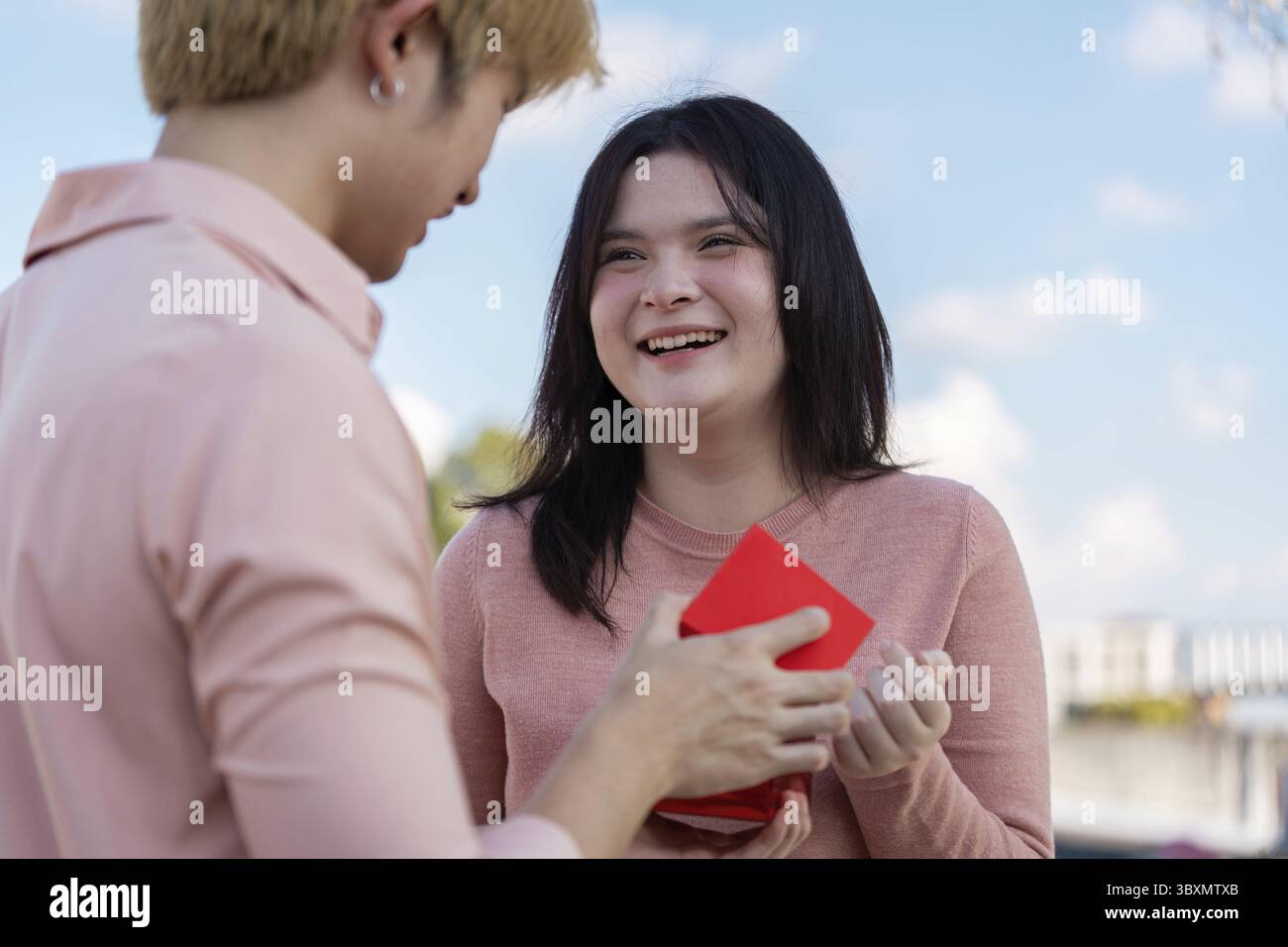 Valentinstag-Überraschungspaar feiert Liebe mit Geschenk im Freien emotionale Verbindung freudiger Moment Stockfoto