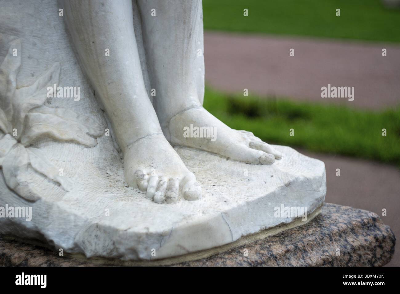 Nahaufnahme der Marmorskulpturfüße im Garten im Freien Stockfoto