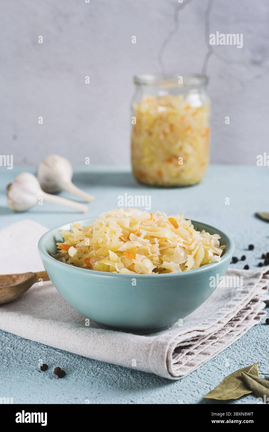 Essen, eingelegtes Sauerkraut mit Karotten in einer Schüssel auf dem Tisch vertikal Stockfoto