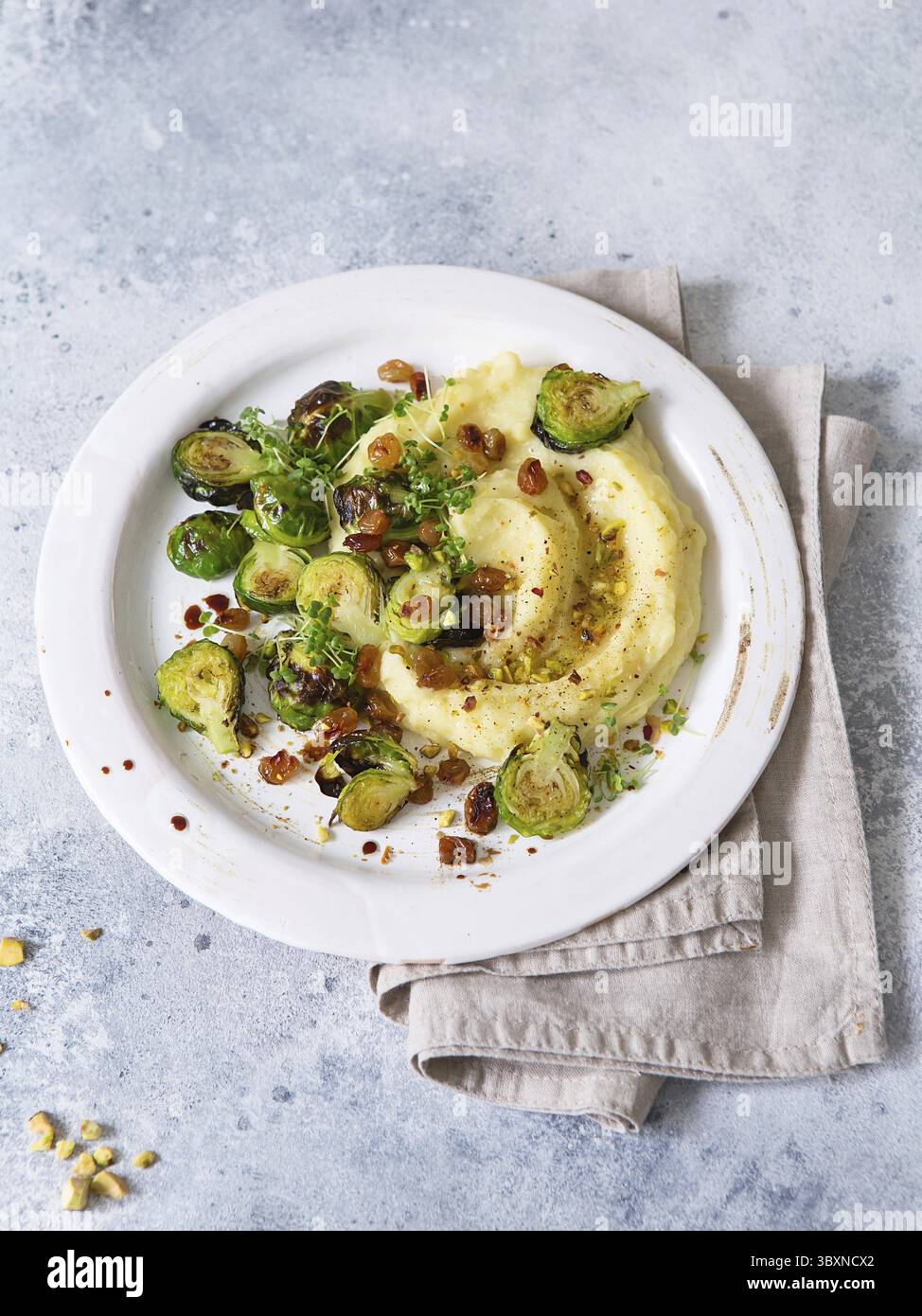 Rosenkohl mit Pistazien, Rosinen und Skordalia (Kartoffelpüree). Gesunde Zubereitung von Mahlzeiten. Gerichte auf pflanzlicher Basis. Grünes Leben. Veganes Rezept. F Stockfoto