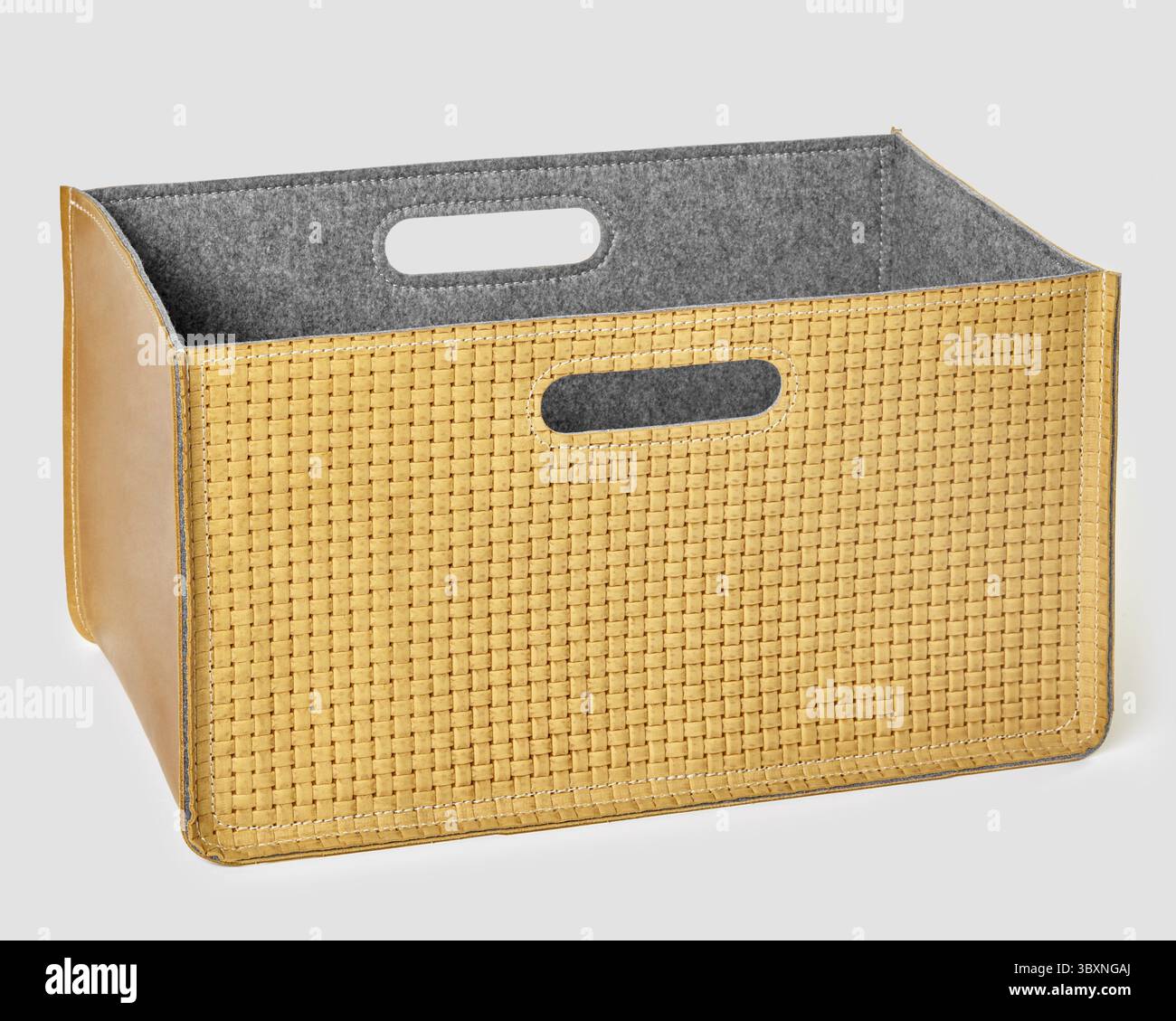 Stilvoller leerer Aufbewahrungskorb aus gewebtem Leder mit Filzfutter und praktischen Griffen, perfekt für die Organisation jedes Raumes Stockfoto