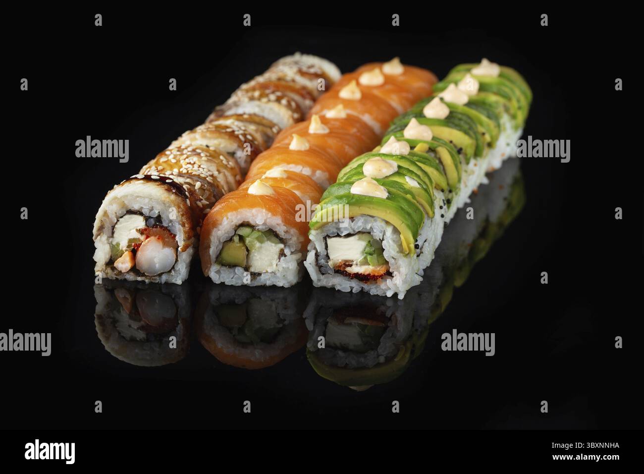 Traditionelle, köstliche, frische Sushi-Rolle auf schwarzem Hintergrund mit Spiegelung. Sushi-Rolle mit Reis, Nori, Frischkäse, Tobiko-Kaviar, Avocado. So Stockfoto