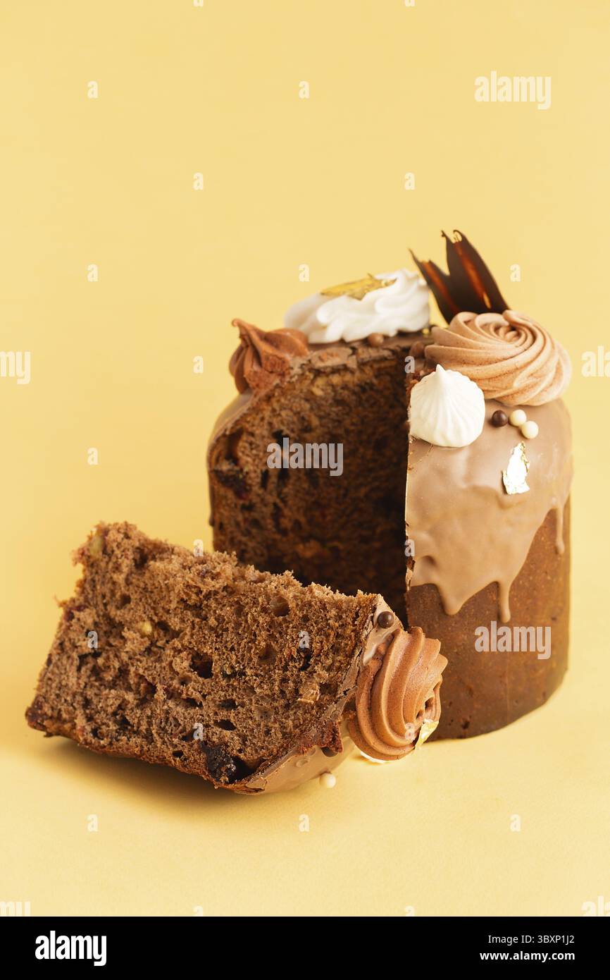 Osterkuchen - Russische und ukrainische traditionelle Kulich mit Süßigkeiten und Marschmalereien auf gelbem Hintergrund dekoriert. Happy East Stockfoto