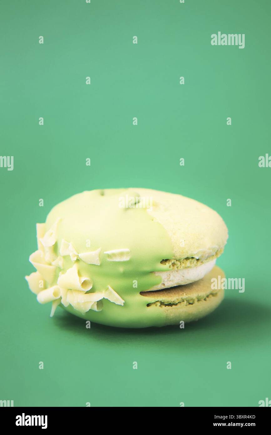 Green Cake Macaron oder Macaron auf grünem Hintergrund. Bunte Mandelkekse. Französische Makronenkuchen-Nahaufnahme. Makronen auf farbigem Hintergrund Stockfoto