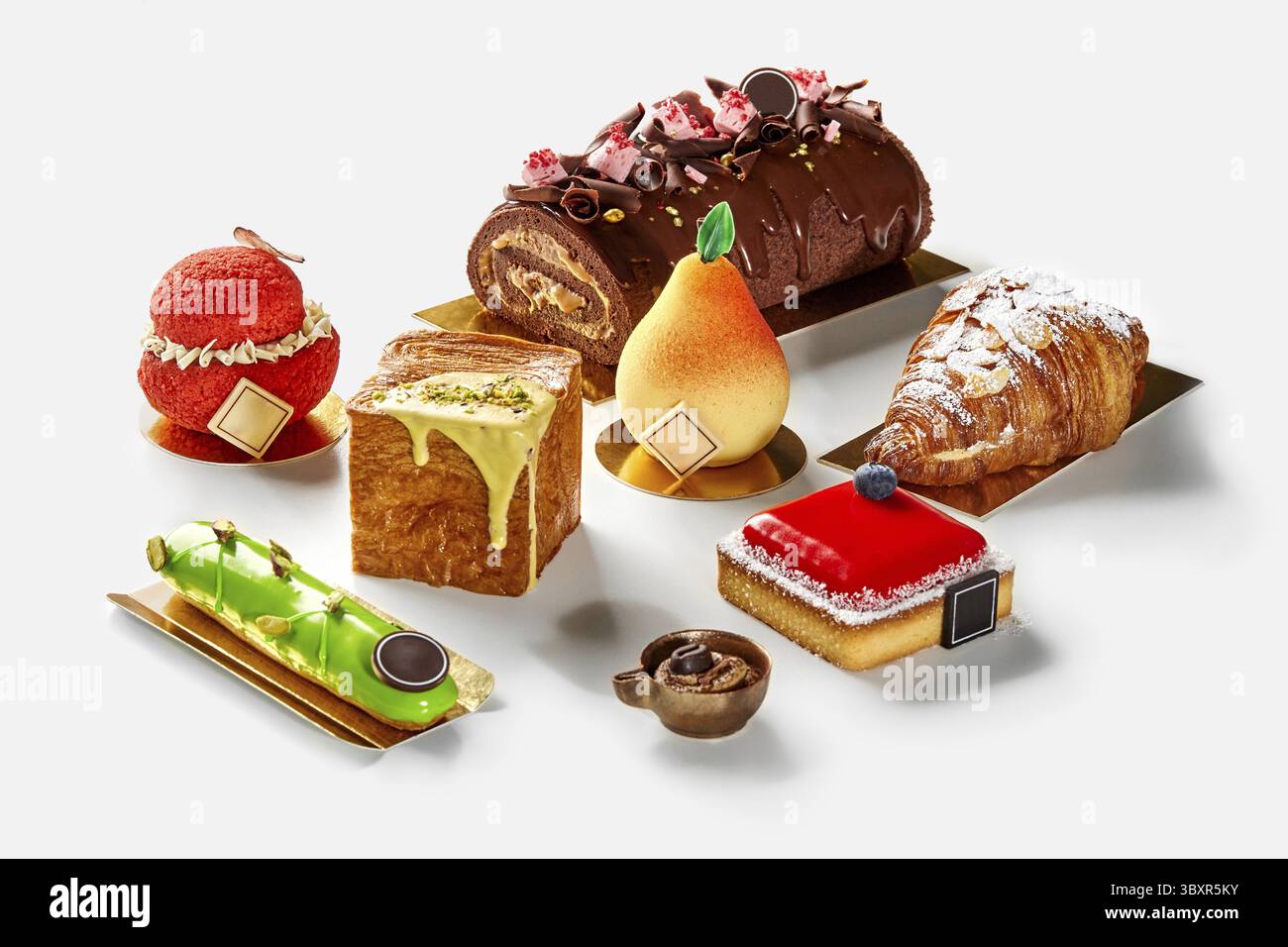 Verschiedene verführerische bunte Backwaren, fruchtiges Gebäck, feiner kleiner Käsekuchen mit Beerengelee, Pistazien-eclair, Schokoladenrolle, Blätterteig Stockfoto