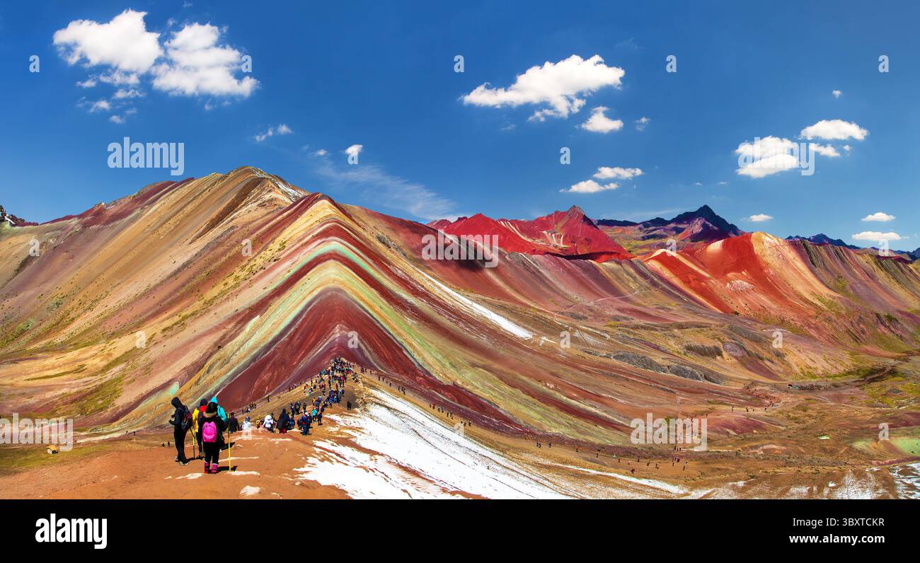 Regenbogenberge oder Vinicunca Montana de Siete Colores mit Touristen und wunderschönen Wolken am Himmel, Cuzco Region in Peru, peruanische Anden, Panorama mou Stockfoto