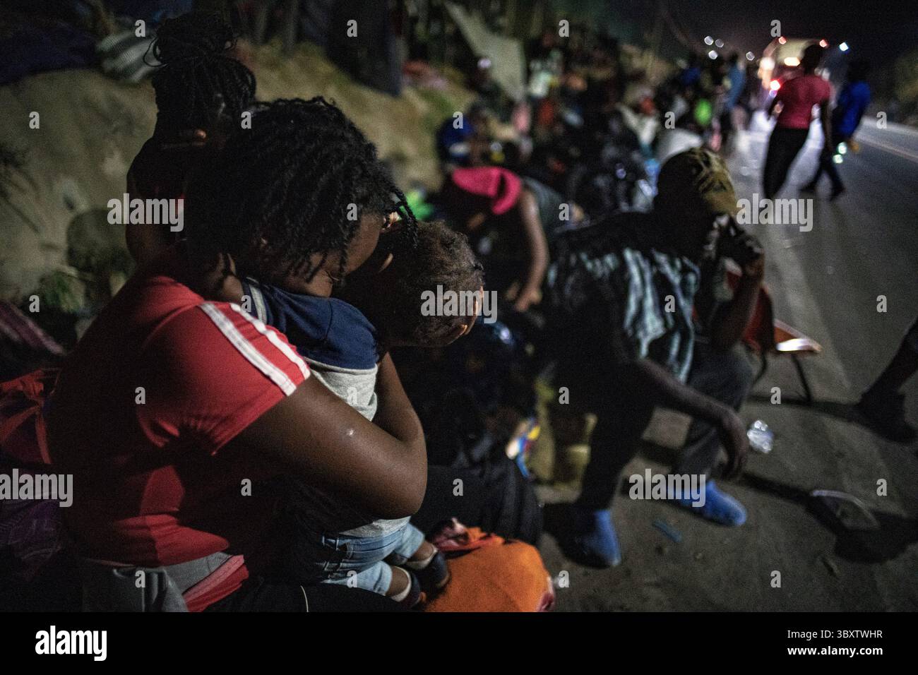 16. Dezember 2021, Tapachula, Chiapas, Mexiko: Haitianische Migranten, darunter DARLINE CHERIZA und ihr Sohn DONLEY, 1, stehen in der Hoffnung, einen Bus zu bekommen, der vom National Institute of Migration an der A-Autobahn auf der Südseite von Tapachula bereitgestellt wird. Das Lager steigt auf mehrere Tausend und bis zu einem Kilometer lang an. Es wurde von einem Mangel an Wasser, Nahrungsmitteln und sanitären Einrichtungen geplagt. (Bild: © Richard Tsong-Taatarii/ZUMA Press Wire) Stockfoto