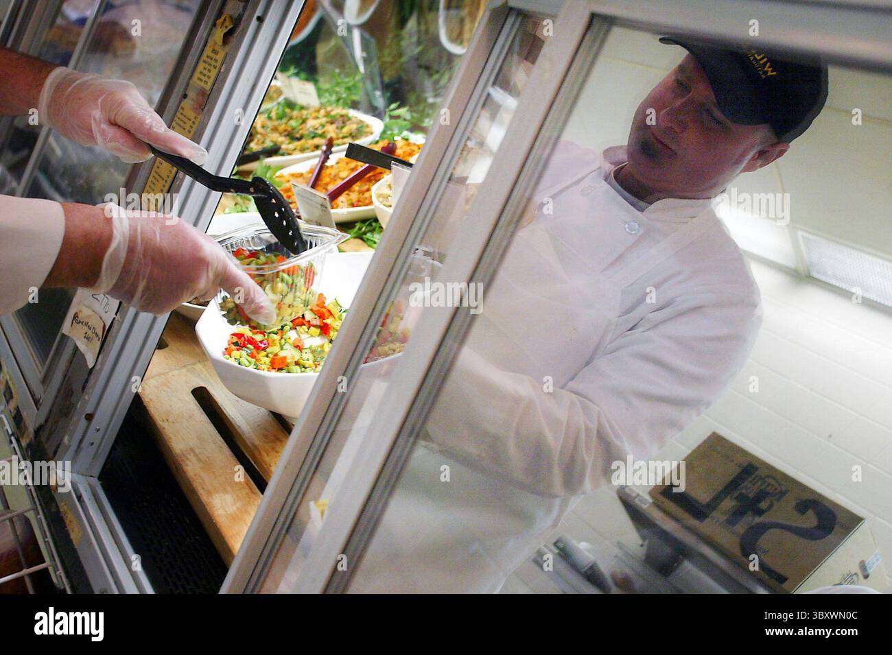 FEBRUAR 2004 - USA - KRT US NEWS STORY SLUGGED: ENV-SCI-CORNPLASTIC KRT FOTO VON KEVIN MANNING/ST. LOUIS POST-DISPATCH (19. Februar) Mark Johnson serviert Gemüse in Plastikbehältern in einem Feinkostgeschäft in St. Louis, Missouri. Die Behälter sind aus Mais gefertigt. (gsb) 2004 (Bild: © Kevin Manning/St Louis Post-Dispatch via ZUMA Press Wire) Stockfoto