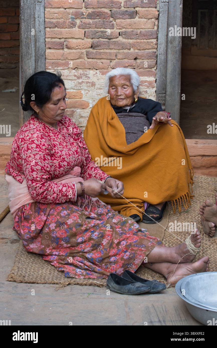 7. Februar 2015, Provinz Bagmati, Nepal: Frauen sitzen auf einer Matte vor einem Haus im mittelalterlichen Newari-Dorf Khokana im Kathmandu-Tal. (Kreditbild: © Jon G. Fuller/VW Pics via ZUMA Press Wire) Stockfoto