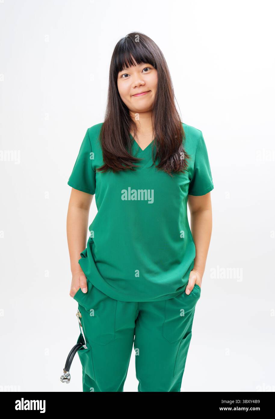 Healthcare Worker in Green Scrubs stehend vor weißem Hintergrund Stockfoto