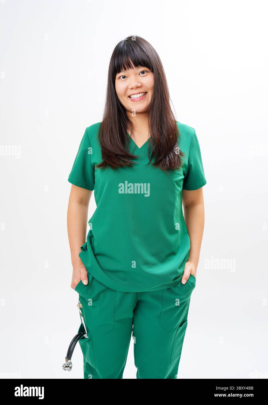 Healthcare Worker in Green Scrubs stehend vor weißem Hintergrund Stockfoto