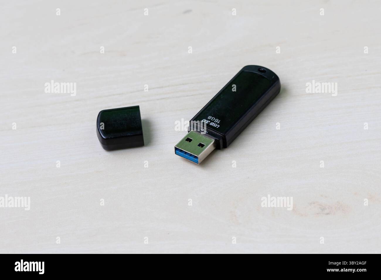 Schwarzer 16-GB-USB-3,0-Pendel auf einer hellen Holzoberfläche, ideal für Technologie, Datenspeicherung und digitale Visualisierungen. Stockfoto