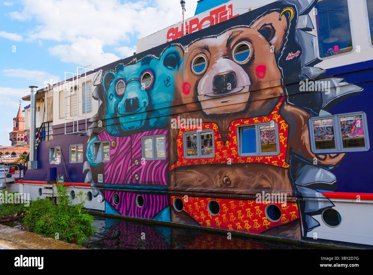 Berlin, Deutschland - 30. Mai 2025: Lebendige Graffiti mit zwei Bären schmücken das Äußere des ShipOtel, einem einzigartigen schwimmenden Hostel in Berlin Stockfoto