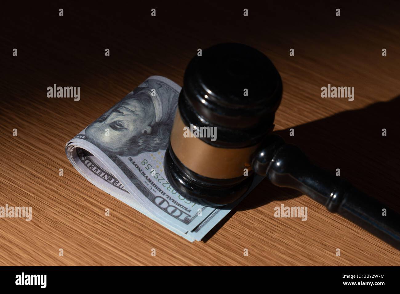 Ein Stapel US-Dollar-Scheine und ein Hammer. Bestechung, Korruption oder legale Geschäfte mit dem Konzept „Geld“. Stockfoto