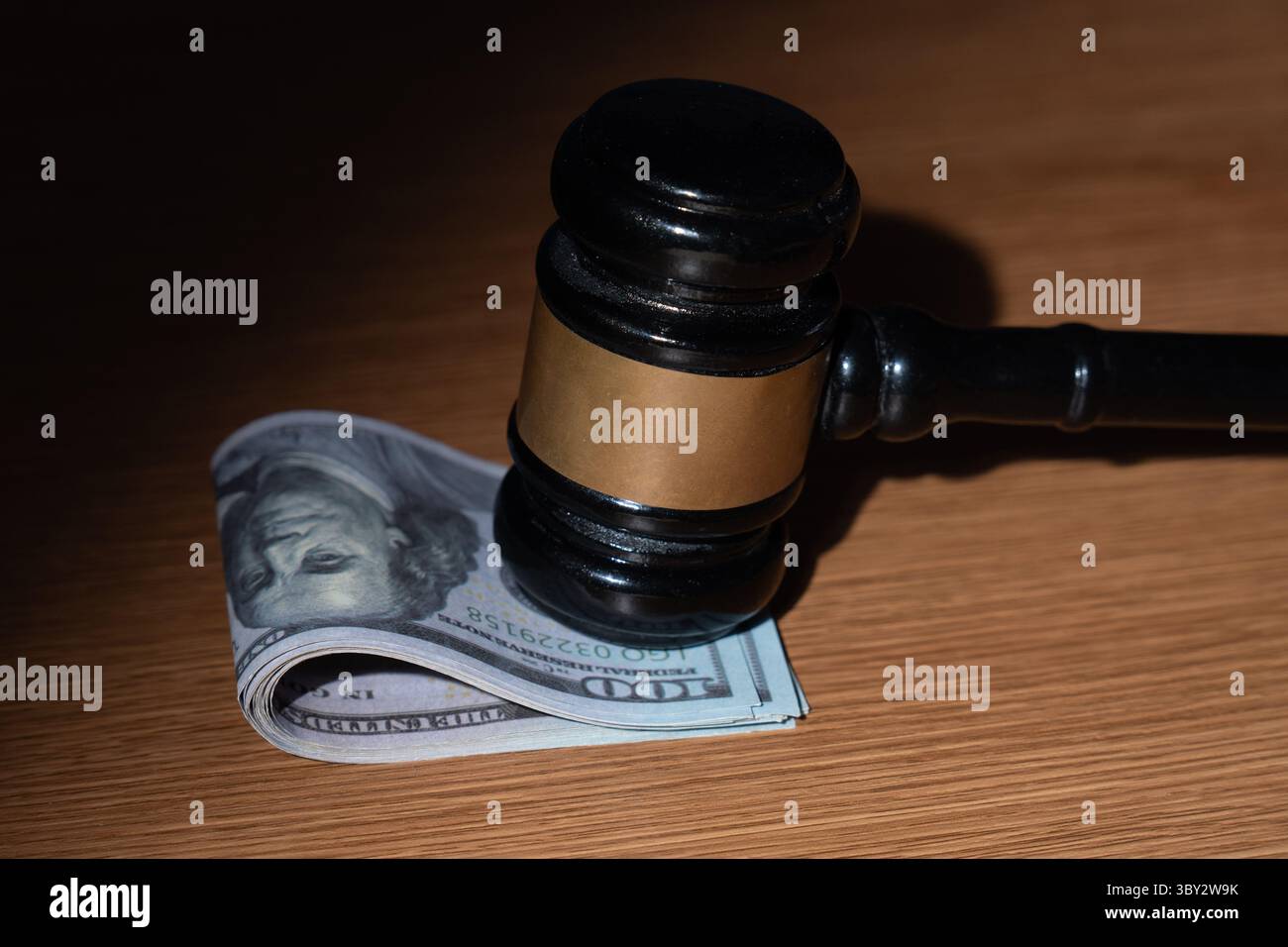 Ein Stapel US-Dollar-Scheine und ein Hammer. Bestechung, Korruption oder legale Geschäfte mit dem Konzept „Geld“. Stockfoto