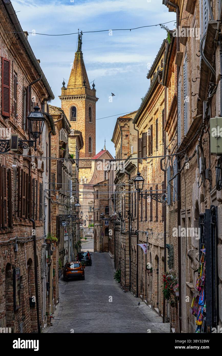 Eine mittelalterliche Straße, die von Backsteinhäusern gesäumt ist, führt zur Kathedrale der Heiligen Gregor und Margarete in Ripatransone. Ripatransone, Ascoli Piceno, Marken Stockfoto