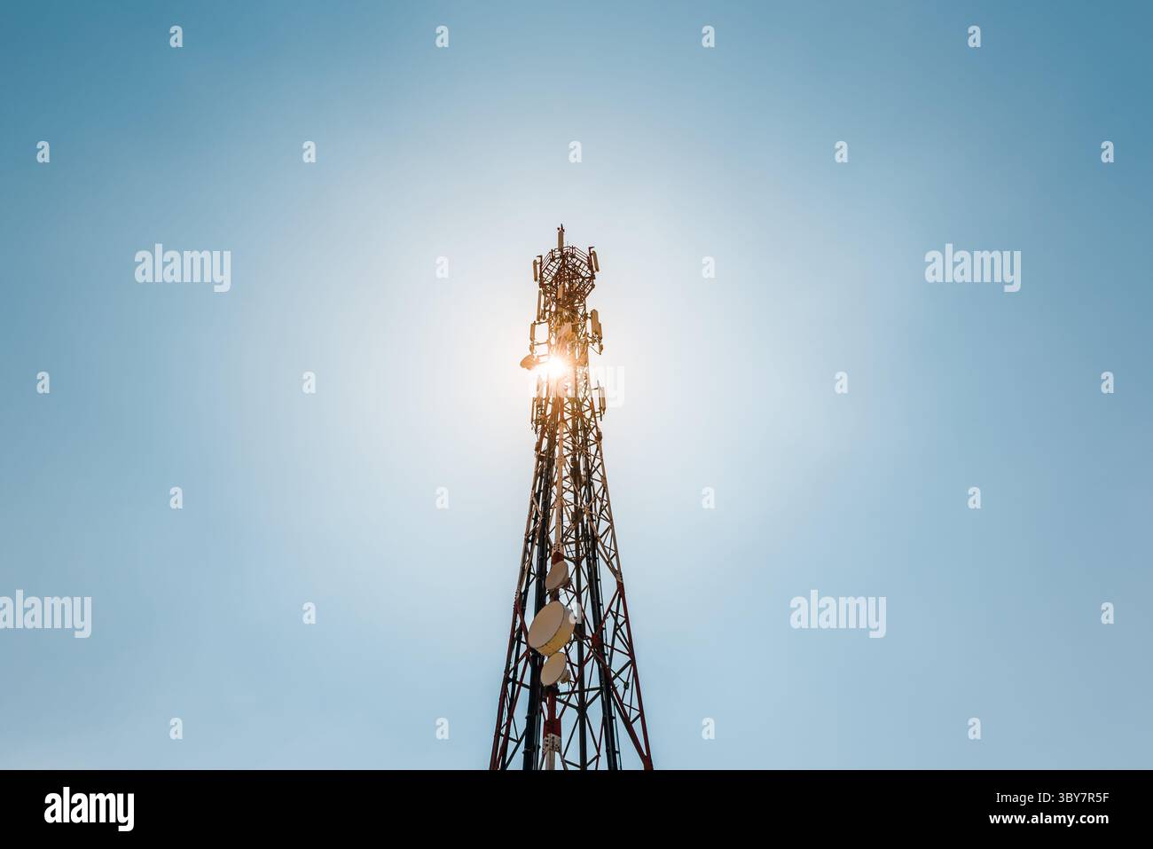 Telekommunikations-TV-Antennen mit Handy-Antennen und Satellitenschüssel mit blauem Himmel im Hintergrund Stockfoto