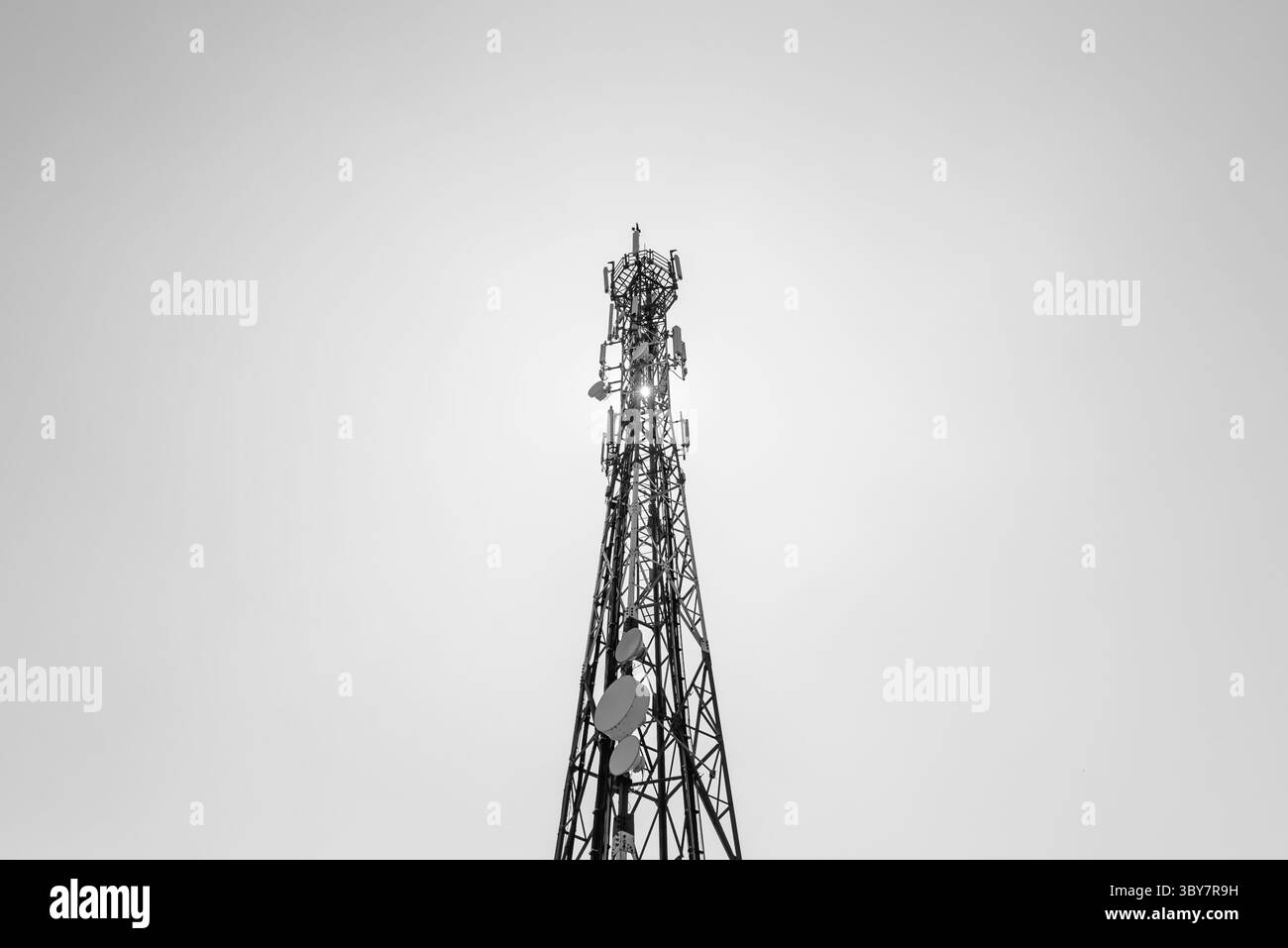 Telekommunikations-TV-Antennen mit Handy-Antennen und Satellitenschüssel mit blauem Himmel im Hintergrund Stockfoto