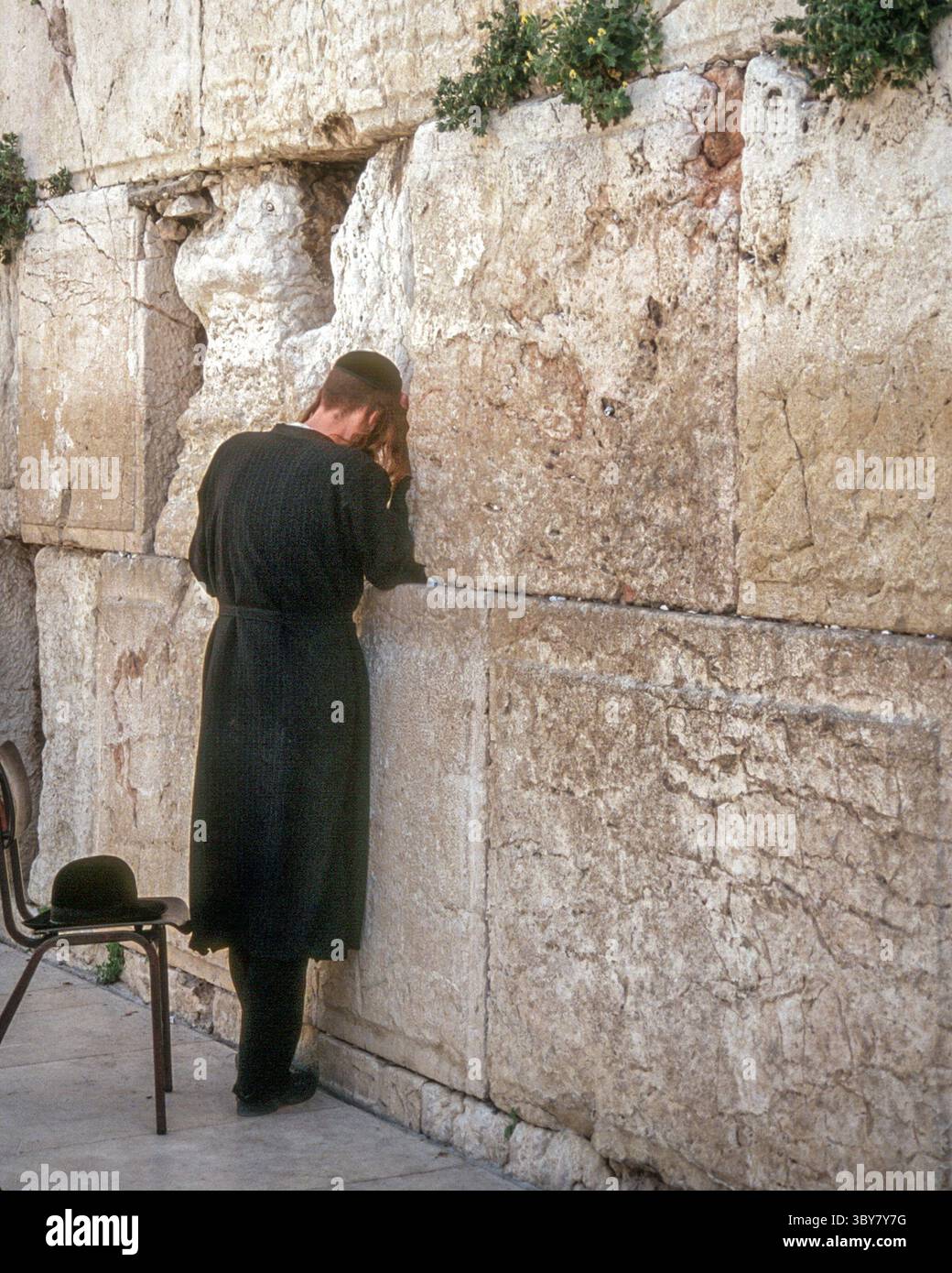 8. April 1988, Jerusalem, Israel: Ein junger religiöser jüdischer Mann beim Gebet an der alten Klagemauer (auch Westmauer oder HaKotel genannt) in der Altstadt von Jerusalem, der heiligsten Stätte des Judentums. Es ist der letzte Überrest der ursprünglichen Stützmauer um den Tempelberg und den Zweiten Tempel, die vor über 2.000 Jahren erbaut wurden. (Bild: © Arnold Drapkin/ZUMA Press Wire) Stockfoto