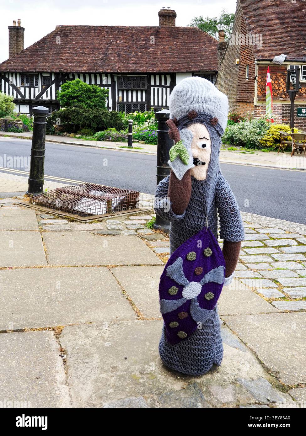 Yarnbombing Strickfigur von König Harold in der Nähe von Battle Abbey mit dem Pilgrims Rest Gebäude dahinter in Battle East Sussex England Stockfoto