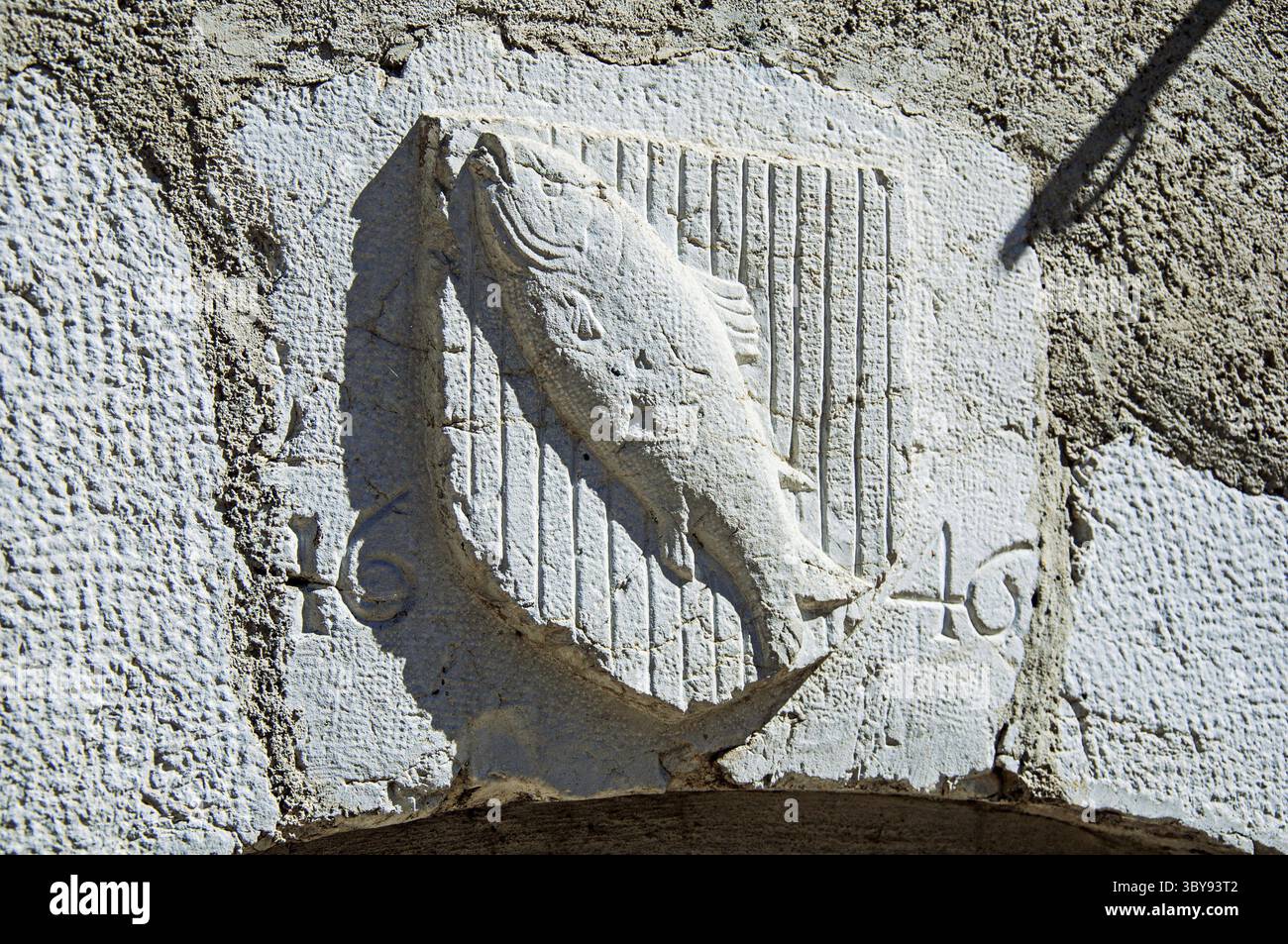 Heraldischer Schild in Stein mit Fischen und Datum im historischen Stadtzentrum von Annecy. Im Departement Haute-Savoie, Auvergne-Rhone- Stockfoto