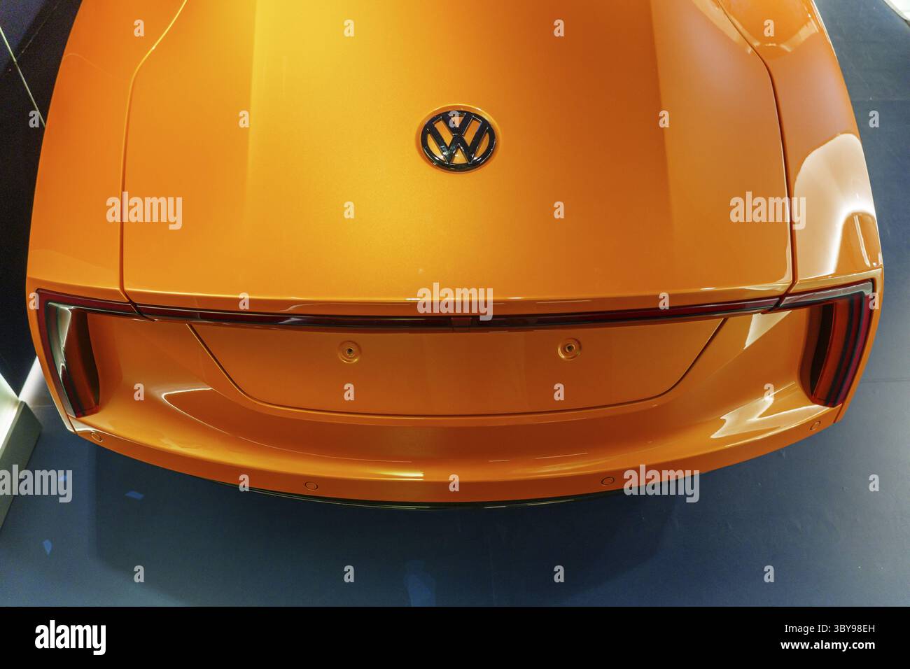 Draufsicht auf ein orangefarbenes VW-Heck mit Emblem auf dem Kofferraum, Einbeck, Deutschland Stockfoto