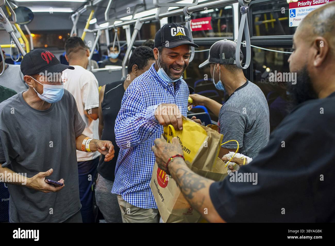 31. August 2022, Chicago, Illinois, USA: Eine Gruppe von Migranten, die mit einem Bus aus Texas ankamen, erhalten Cheeseburger, während sie sich auf die Fahrt mit dem CTA-Bus zu einem Schutzraum der Heilsarmee vorbereiten. Die Menschen, die aus anderen Ländern nach Texas eingewandert waren, wurden per Bus von Texas Gouverneur Abbott geschickt. 75 Migranten, die in Texas ankamen, wurden an Chicagos Union Station abgesetzt. (Bild: © Armando L. Sanchez/Chicago Tribune via ZUMA Press Wire) Stockfoto