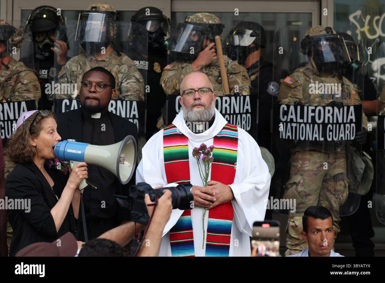Los Angeles, Kalifornien, USA. Juni 2025. Pater Brendan Busse schließt sich den Geistlichen VON LA während eines ICE-Einwanderungsprotests an, als Mitglieder der California National Guard am 10. Juni 2025 eine Perimeter am Los Angeles Street Federal Building in Los Angeles, CA, halten. (Credit Image: © Jonathan Alcorn/ZUMA Press Wire) NUR REDAKTIONELLE VERWENDUNG! Nicht für kommerzielle ZWECKE! Stockfoto