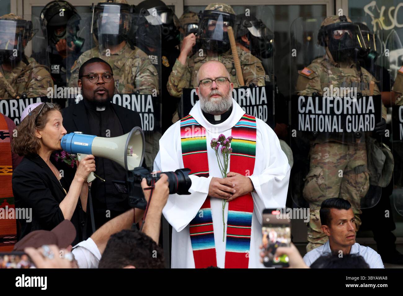Los Angeles, Kalifornien, USA. Juni 2025. Pater Brendan Busse schließt sich den Geistlichen VON LA während eines ICE-Einwanderungsprotests an, als Mitglieder der California National Guard am 10. Juni 2025 eine Perimeter am Los Angeles Street Federal Building in Los Angeles, CA, halten. (Credit Image: © Jonathan Alcorn/ZUMA Press Wire) NUR REDAKTIONELLE VERWENDUNG! Nicht für kommerzielle ZWECKE! Stockfoto