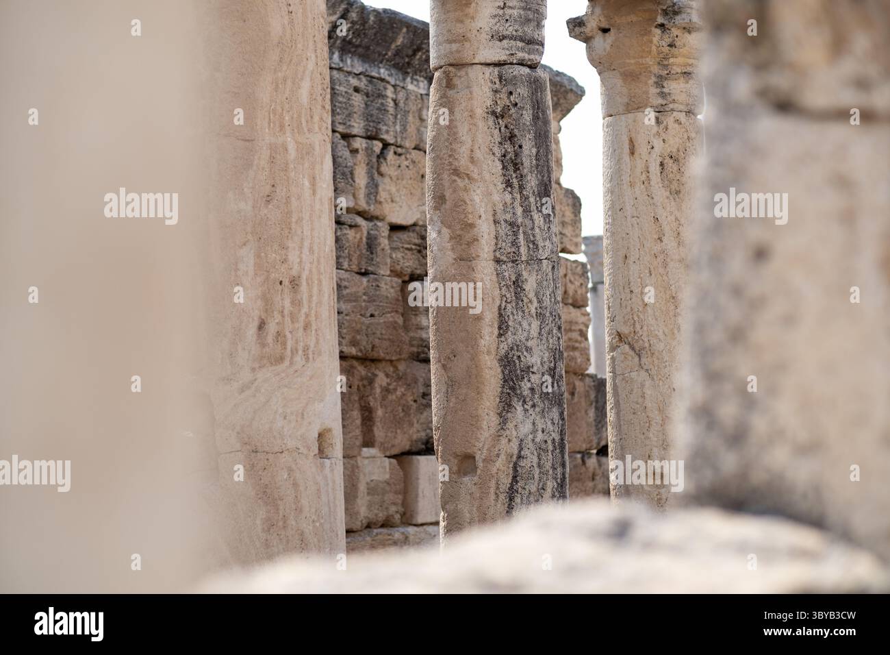 Entdecken Sie die bemerkenswerten Ruinen in Pamukkale, die antike Steinsäulen und komplizierte Strukturen inmitten der atemberaubenden Landschaften dieser Historica zeigen Stockfoto